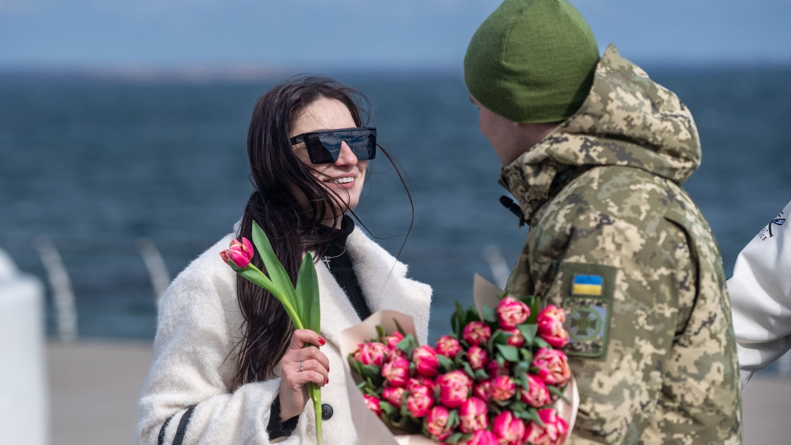 Детальніше про статтю Одеські прикордонники з весняними квітами привітали жінок на узбережжі
